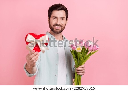 Photo portrait of attractive young man giftbox bouquet tulips valentine day dressed stylish blue outfit isolated on pink color background