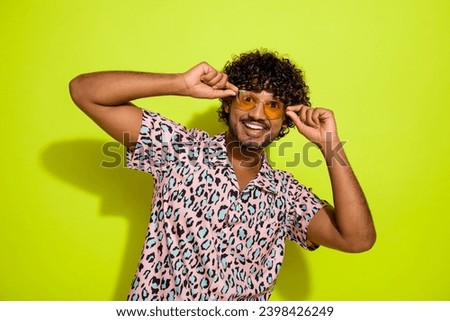 Photo portrait of attractive young man touch sunglass model wear trendy pink leopard print clothes isolated on yellow color background