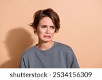 Photo portrait of attractive young woman look disgusted empty space dressed stylish gray clothes isolated on beige color background