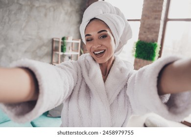 Photo portrait of attractive young woman selfie photo winking smile head wrapped towel dressed bath robe home interior enjoy weekend - Powered by Shutterstock