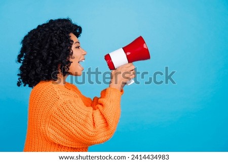 Photo portrait of attractive young woman profile announce megaphone wear trendy knitwear orange clothes isolated on blue color background