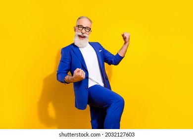 Photo Portrait Of Bearded Man In Spectacles Blue Suit Gesturing Like Winner Isolated Bright Yellow Color Background