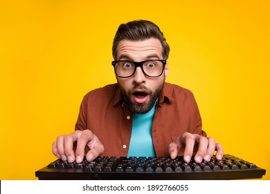 Photo portrait of bearded man staring playing video game crazy nerd pressing keyboard spectacles isolated on bright yellow color background