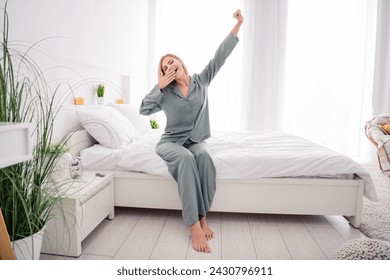 Photo portrait of blonde attractive young woman sit bed stretch yawn dressed stylish gray pajama light modern bedroom minimalist design - Powered by Shutterstock