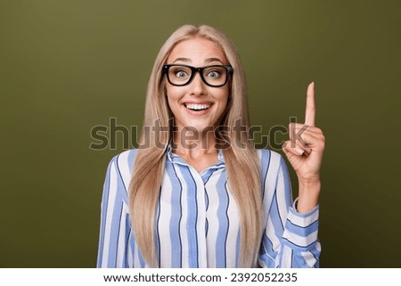 Photo portrait of blonde lovely young lady excited point up eureka dressed stylish striped garment isolated on khaki color background