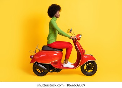 Photo portrait of brunette african american woman riding red motorbike isolated on vivid yellow colored background - Powered by Shutterstock