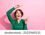 Photo portrait of charming girl brown bob hair pointing fingers empty space interested surprised reaction isolated on pink color background