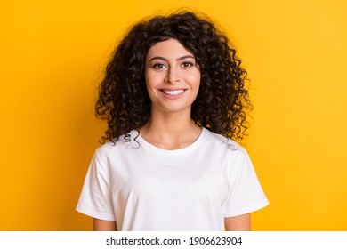 Photo Portrait Of Cheerful Curly Brunette Wearing White T-shirt Smiling Isolated On Bright Yellow Color Background