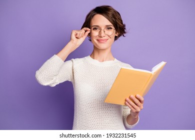 Photo portrait of clever female student touching spectacles keeping book isolated on bright violet color background - Shutterstock ID 1932231545