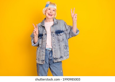 Photo Portrait Of Cool Positive Granny Smiling Showing V-sign Gesture Isolated On Vivid Yellow Color Background