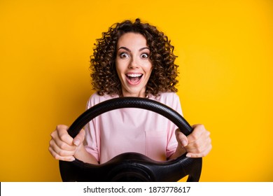 Photo portrait of crazy mad cheerful female driver keeping steering wheel staring isolated on vibrant yellow color background