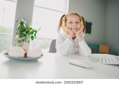 Photo portrait of cute adorable girl headphones eat lunch sweets cheerful remote lesson education from home indoors - Powered by Shutterstock