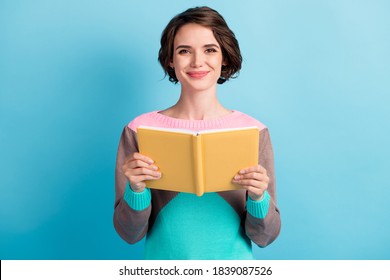 Photo Portrait Of Cute Female Girl With Short Hair Keeping Yellow Book Smiling Isolated On Bright Blue Color Background