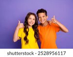 Photo portrait of cute little boy girl thumb up approve dressed stylish yellow orange clothes isolated on purple color background