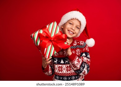 Photo portrait of cute little boy hold present box celebrate christmas wear knitwear sweater isolated on red color background - Powered by Shutterstock