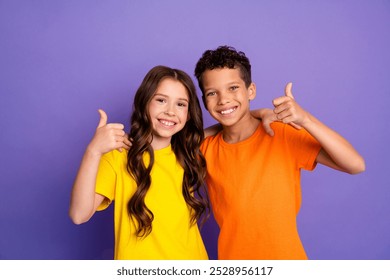 Photo portrait of cute little boy girl thumb up approve dressed stylish yellow orange clothes isolated on purple color background - Powered by Shutterstock