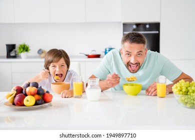 Photo Portrait Of Dad And Son Eating Cereal With Milk Fruits Having Breakfast On White Kitchen