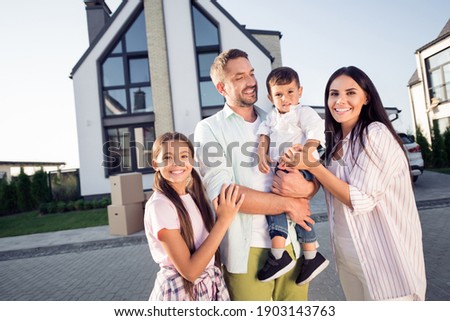 Photo portrait of full big family small daughter son wife husband hugging smiling outside new apartment in summer