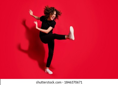 Photo Portrait Full Body View Of Crazy Rebel Girl Kicking Raising Leg Isolated On Vivid Red Colored Background With Blank Space