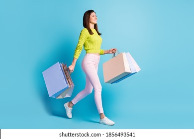 Photo portrait full body view of woman walking with shopping bags isolated on pastel blue colored background