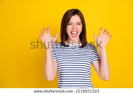 Photo portrait of funky young lady fooling show fingers claws growl tiger wear stylish striped garment isolated on yellow color background