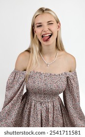 Photo portrait of a funny blonde grimacing and sticking out her tongue.