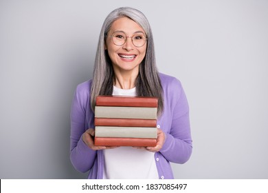Photo portrait of funny smiling granny wearing casual purple cardigan keeping pile of books laughing isolated on grey color background - Shutterstock ID 1837085497