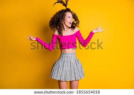 Photo portrait of goofy girl jumping with silly ponytail with raised hands wearing fuchsia crop-top isolated on bright yellow colored background