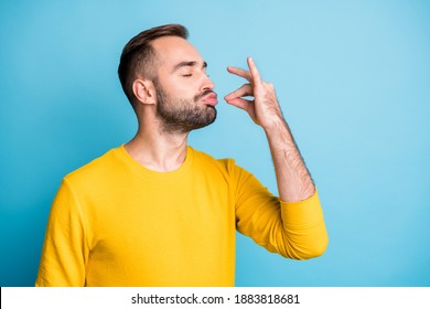 Photo portrait of guy with pouted lips showing gourmet sign with fingers tasty delicious isolated on vibrant blue color background