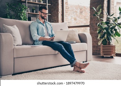 Photo Portrait Of Guy Working On Laptop Sitting On Couch In Modern Industrial Office Indoors