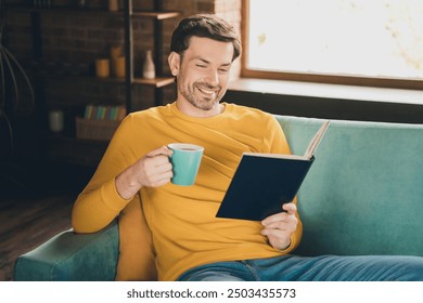 Photo portrait of handsome mature man read book drink tea sit couch dressed yellow outfit cozy day light home interior living room - Powered by Shutterstock