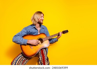 Photo portrait of handsome young male play guitar musician dressed stylish denim garment isolated on yellow color background - Powered by Shutterstock