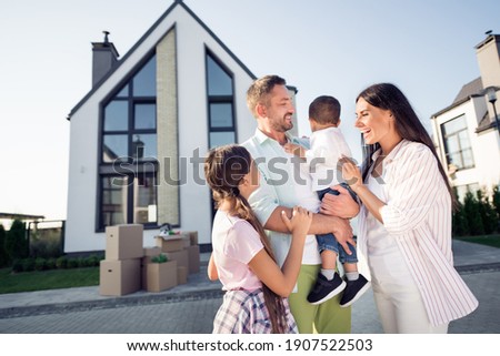 Photo portrait of happy couple of husband wife with small children dad keeping son on hands after relocating in new home in summer