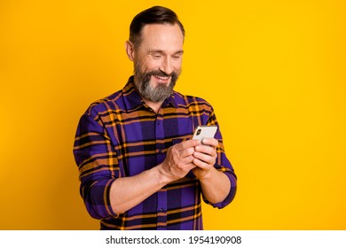 Photo Portrait Of Happy Smiling Man Using Cellphone Smiling Browsing Internet Isolated On Bright Yellow Color Background