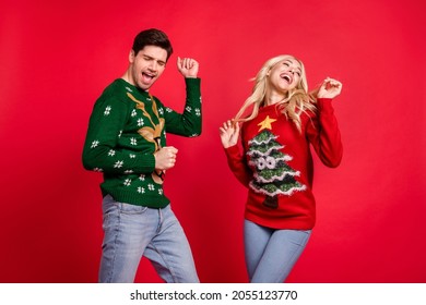 Photo portrait laughing couple wearing pullovers dancing at xmas party on holidays isolated vivid red color background