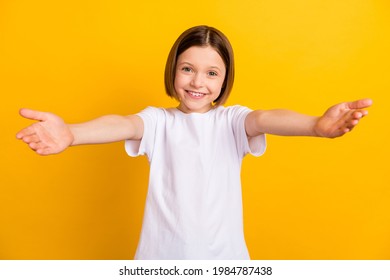 Photo portrait little girl bob hairdress keeping hands forward embracing isolated vivid yellow color background
