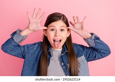 Photo portrait of little girl playful girlish grimacing showing tongue isolated on pastel pink color background