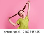 Photo portrait of lovely little girl pulling tails stick tongue dressed stylish green garment isolated on pink color background