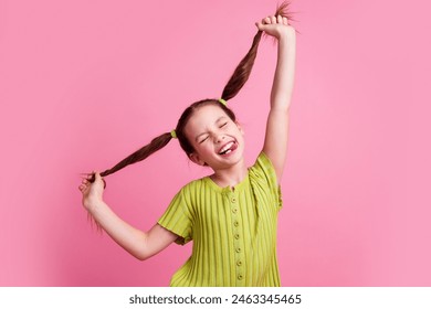 Photo portrait of lovely little girl pulling tails stick tongue dressed stylish green garment isolated on pink color background - Powered by Shutterstock