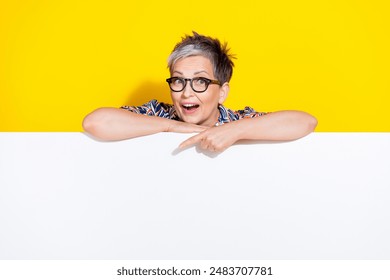 Photo portrait of lovely senior lady point down empty space dressed stylish colorful garment isolated on yellow color background - Powered by Shutterstock