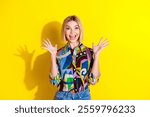 Photo portrait of lovely young lady raise hands excited dressed stylish colorful garment isolated on yellow color background