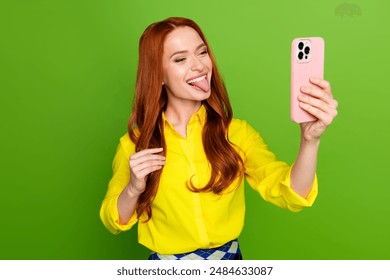 Photo portrait of lovely young lady take selfie photo stick tongue out dressed stylish yellow garment isolated on green color background