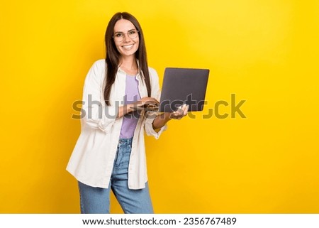 Photo portrait of lovely young lady hold netbook smm manager working wear trendy white garment isolated on yellow color background