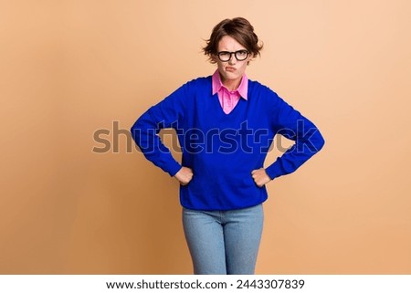 Photo portrait of lovely young lady frowning angry fists waist wear trendy blue garment isolated on beige color background
