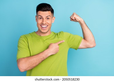 Photo Portrait Man In Green T-shirt Showing Finger Strong Biceps Isolated Pastel Blue Color Background