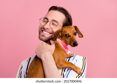 Photo portrait man in t-shirt glasses embracing brown puppy isolated pastel pink color background