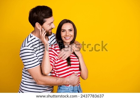 Photo portrait of nice young couple hugging sweet relationship wear trendy striped outfit isolated on yellow color background