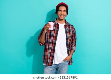 Photo portrait of nice young guy hold paper cup look empty space dressed stylish checkered clothes isolated on cyan color background - Powered by Shutterstock