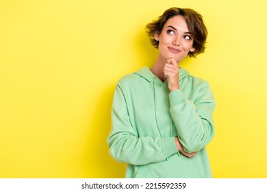 Photo Portrait Of Nice Young Lady Touch Chin Clever Idea Look Empty Space Dressed Stylish Green Garment Isolated On Yellow Color Background