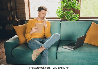 Photo portrait of nice young man sit couch online study write notebook minded wear yellow clothes modern interior flat indoors